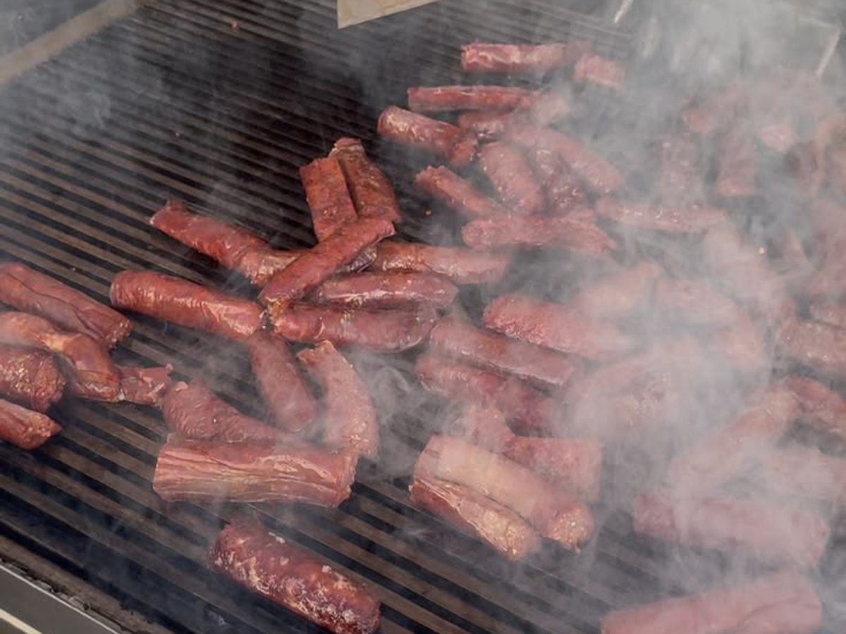 Frisch gegrillte Fleischspezialitäten werden am Grill aufgeschnitten